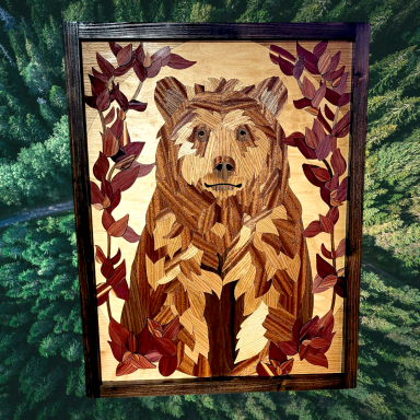 Wooden mosaic of a bear surrounded by leaves, featuring warm brown and red tones.