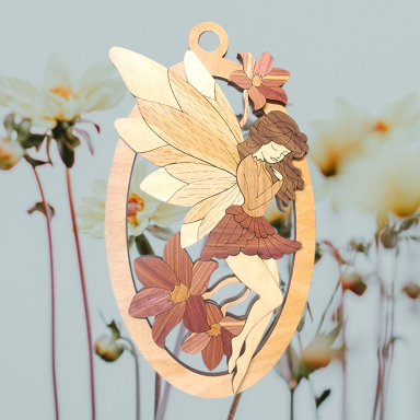 A wooden fairy pendant surrounded by soft, floral background.
