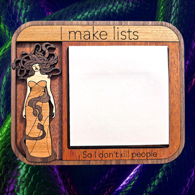 Wooden notepad holder with a figure and the phrase "I make lists So I don't kill people."