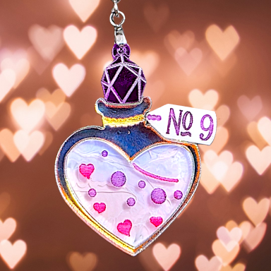 Colorful heart-shaped bottle with hearts and a tag labeled "No 9" on a soft, blurred background.